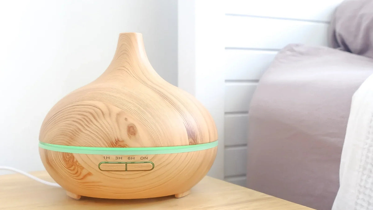 Ultrasonic essential oil diffuser releasing a cool mist in a cosy bedroom