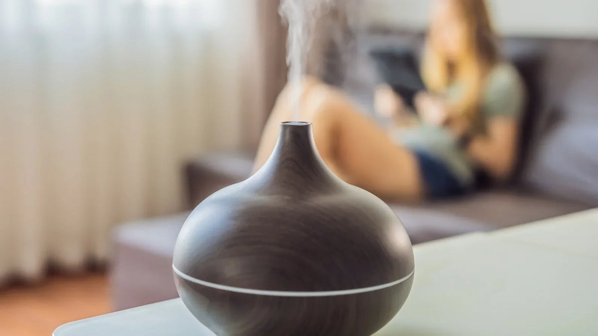 Ultrasonic diffuser releasing a fine scented mist in a bright, calm living room