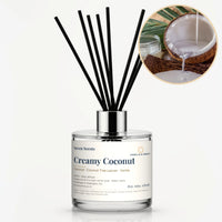 Creamy Coconut Reed Diffuser by Seven Scents - glass bottle with coconut milk pouring into a coconut shell