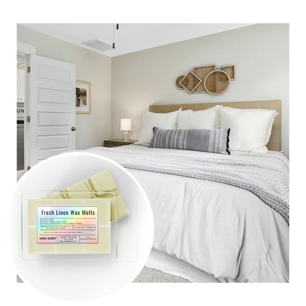 Bedroom with a bed and nightstand, featuring 'Fresh Linen Wax Melts' packaging.