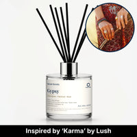 Gypsy Reed Diffuser by Seven Scents - glass bottle with ringed hands on a red patterned dress