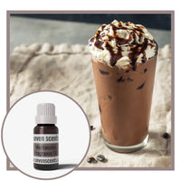 Chocolate drink with whipped cream and a bottle of Seven Scents Mochaccino fragrance oil on a textured surface.