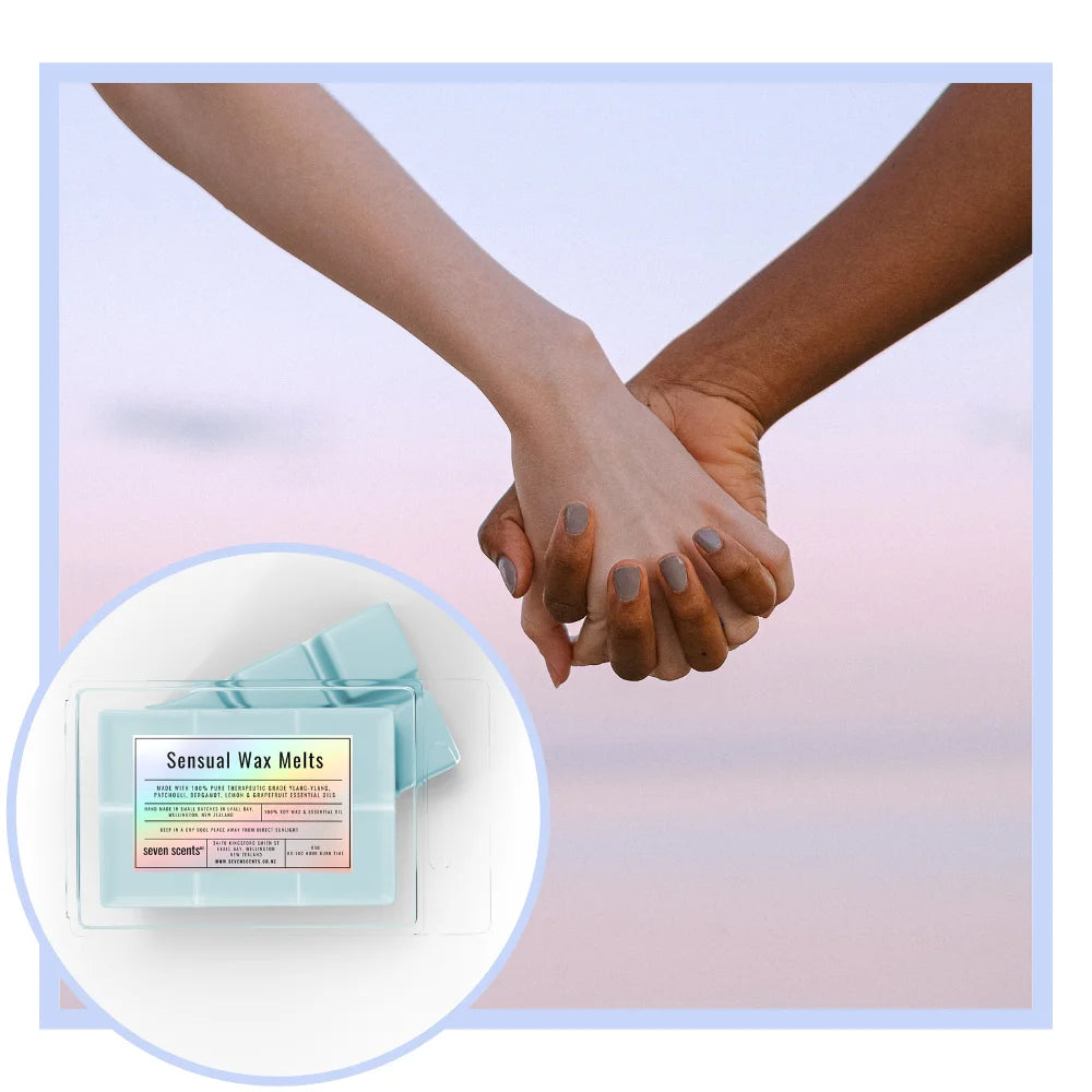 Two hands holding each other with a close-up of Sensual Wax Melts packaging.