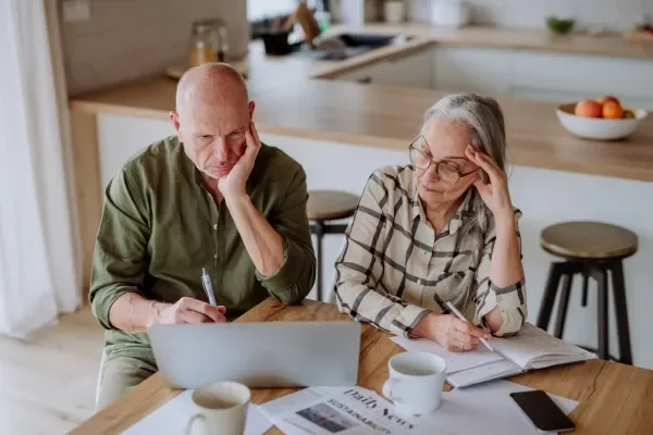 Stressed elderly couple calculating finances